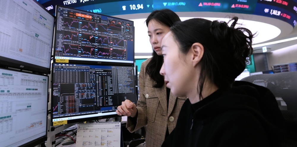 متعاملتان تطالعان شاشات التداول في كوريا